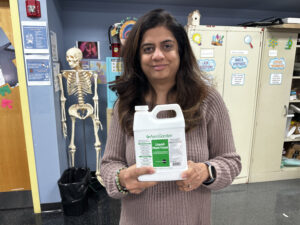 Ms. Shah holding plant food for Grow Towers